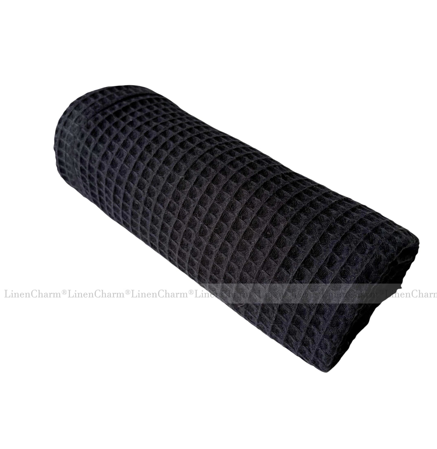 Rolled-up black textured blanket on a white background