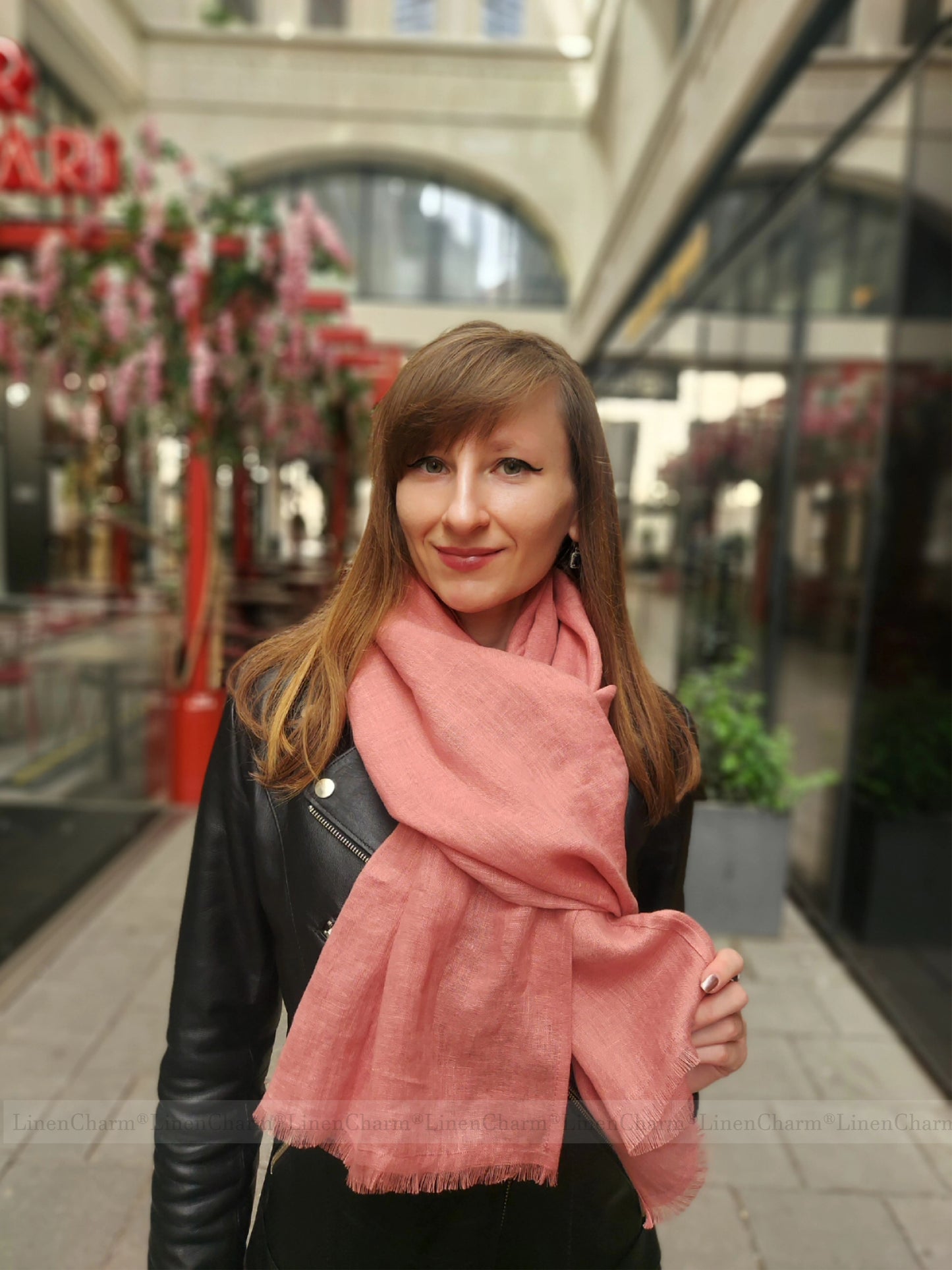 Woman wearing a pink scarf in an indoor shopping mall setting