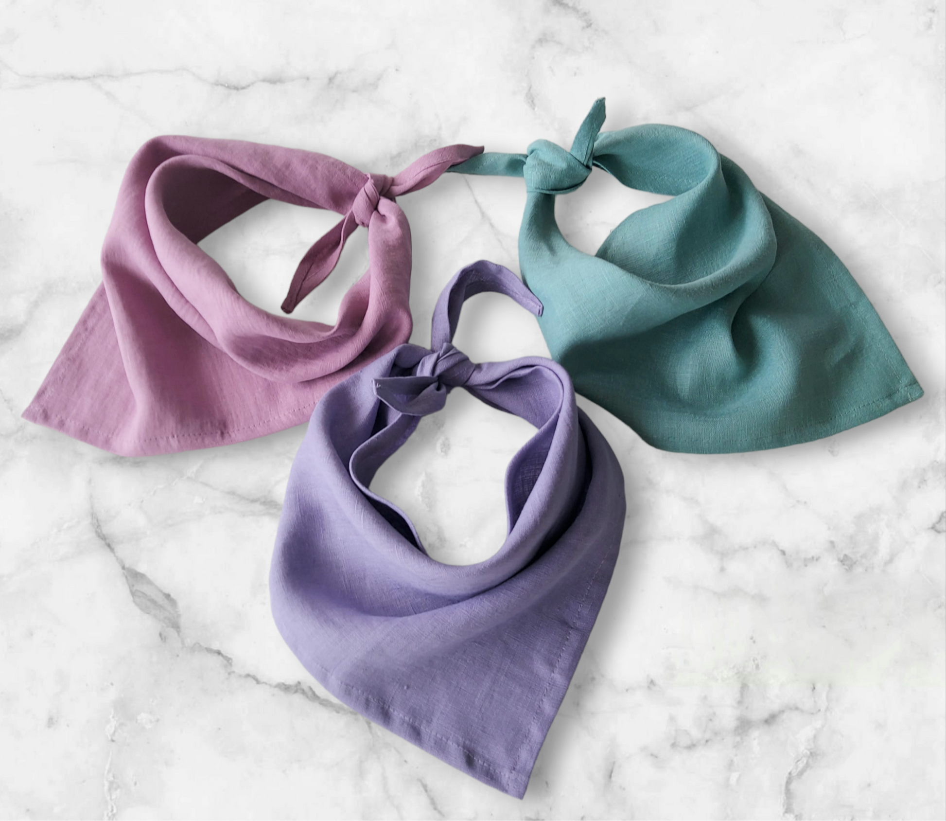 Multiple color options of linen bandana displayed flat