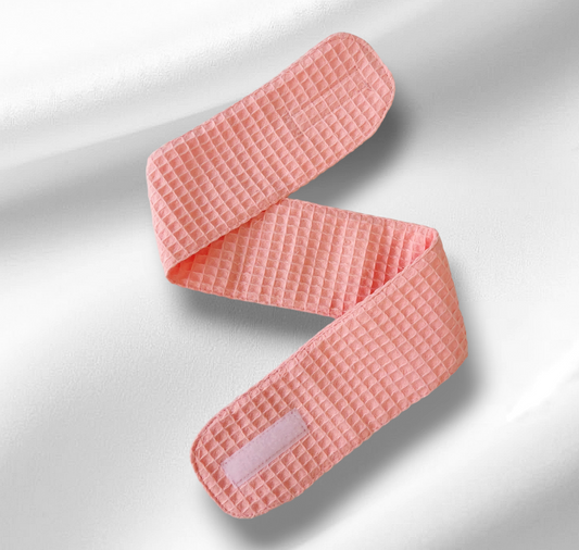 Pink textured belt on a light gray background