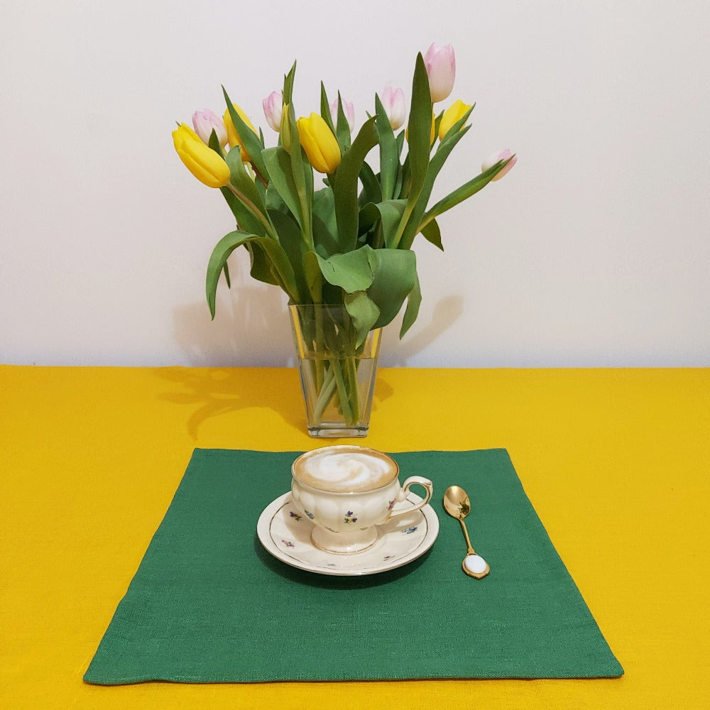 Rustic dinner table with green heavy linen napkins and wood accents