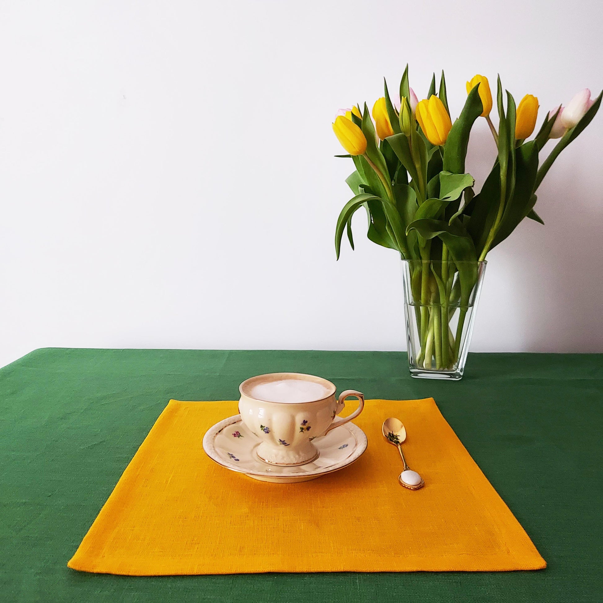 Summer table with yellow linen napkins and floral decor