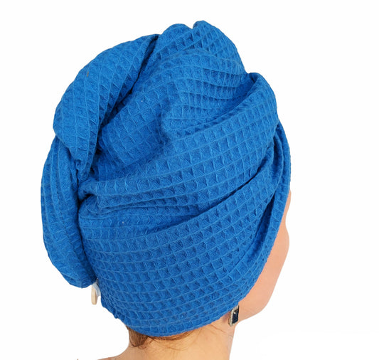 Blue textured towel wrapped around a person's head on a white background