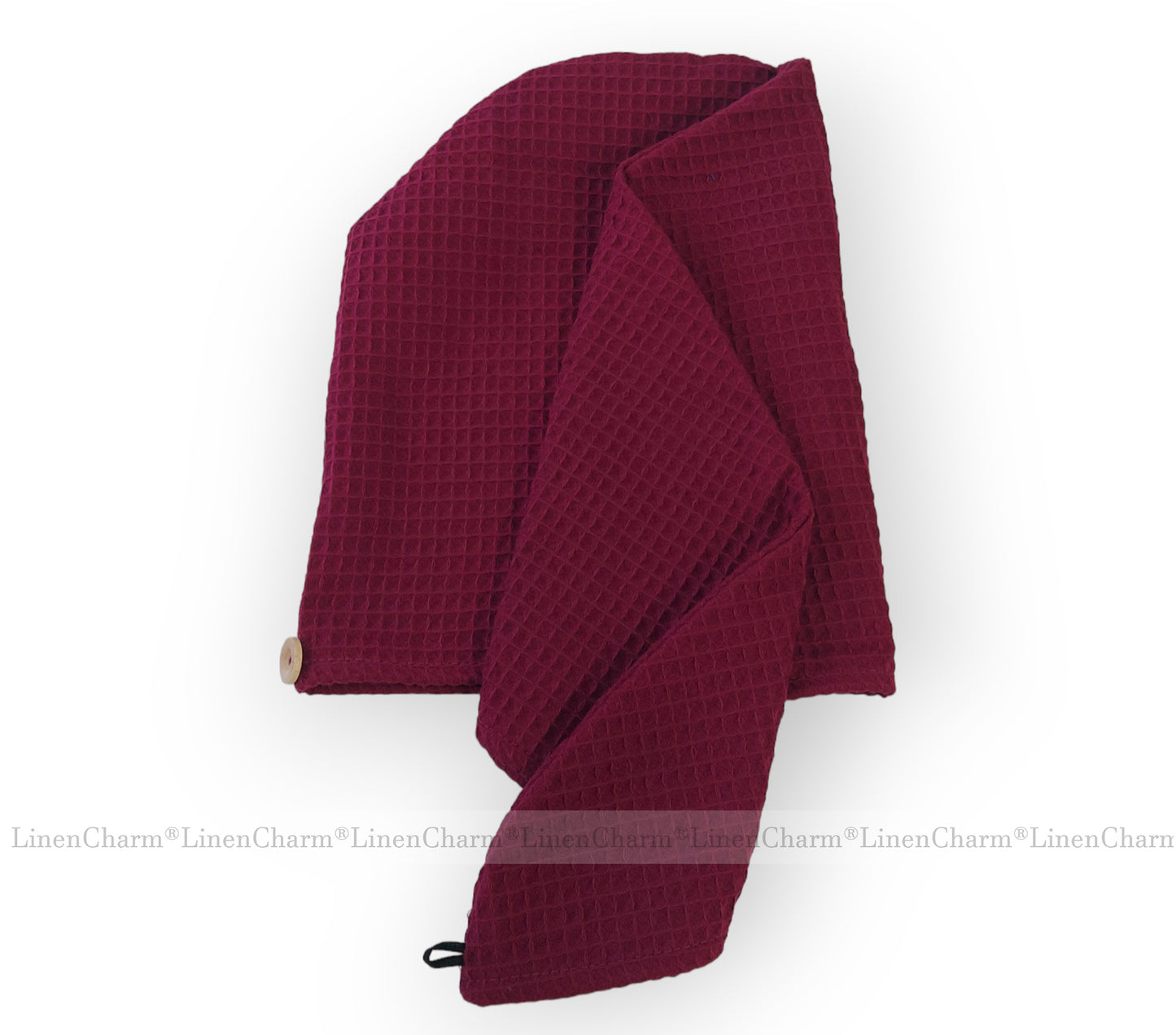 Folded burgundy waffle towel turban on a white background