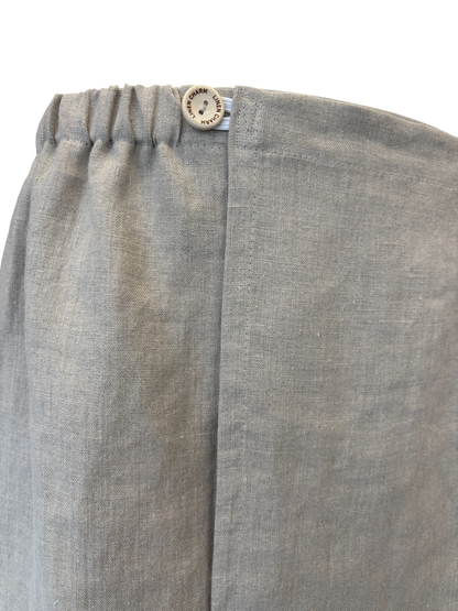 Close-up of gray pants with a button on a white background