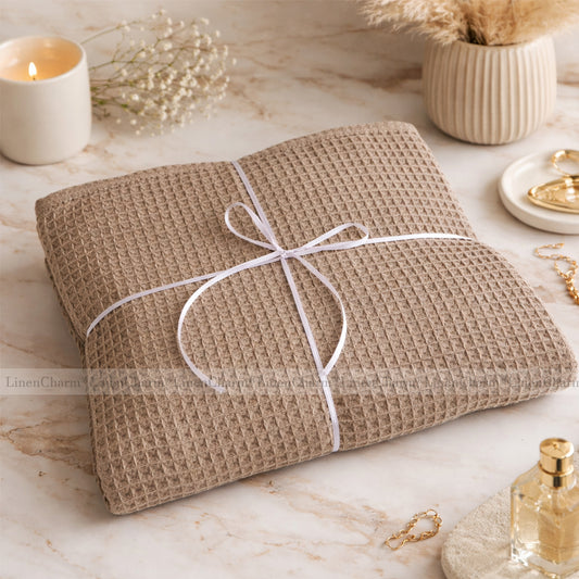 Waffle-textured towel wrapped with string on a marble surface with decorative items.