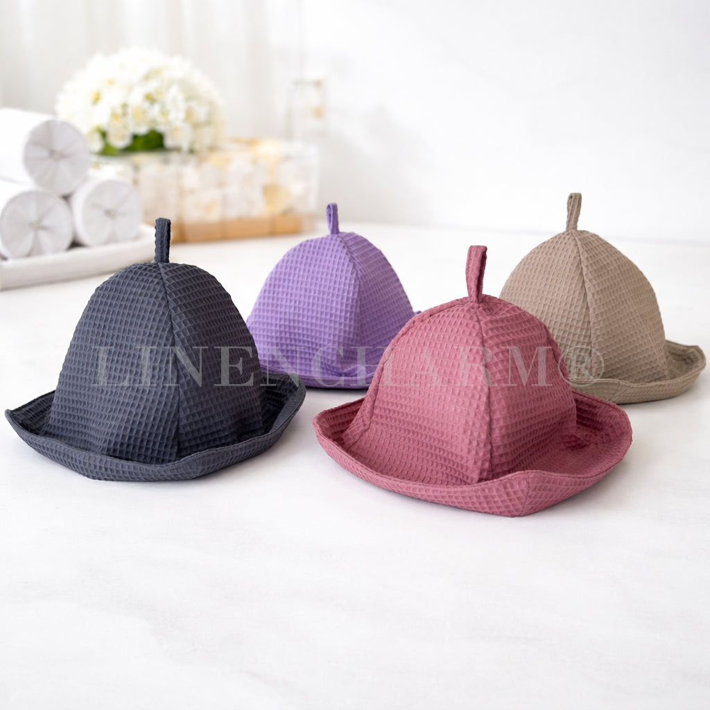 Collection of waffle cotton sauna hats available in anthracite, lilac, dusty pink, and taupe colors.