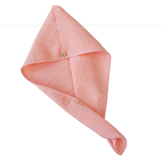 Pink textured towel folded neatly on a white background