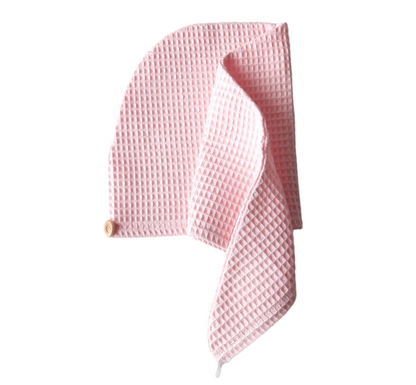 Pink waffle-textured towel on a white background