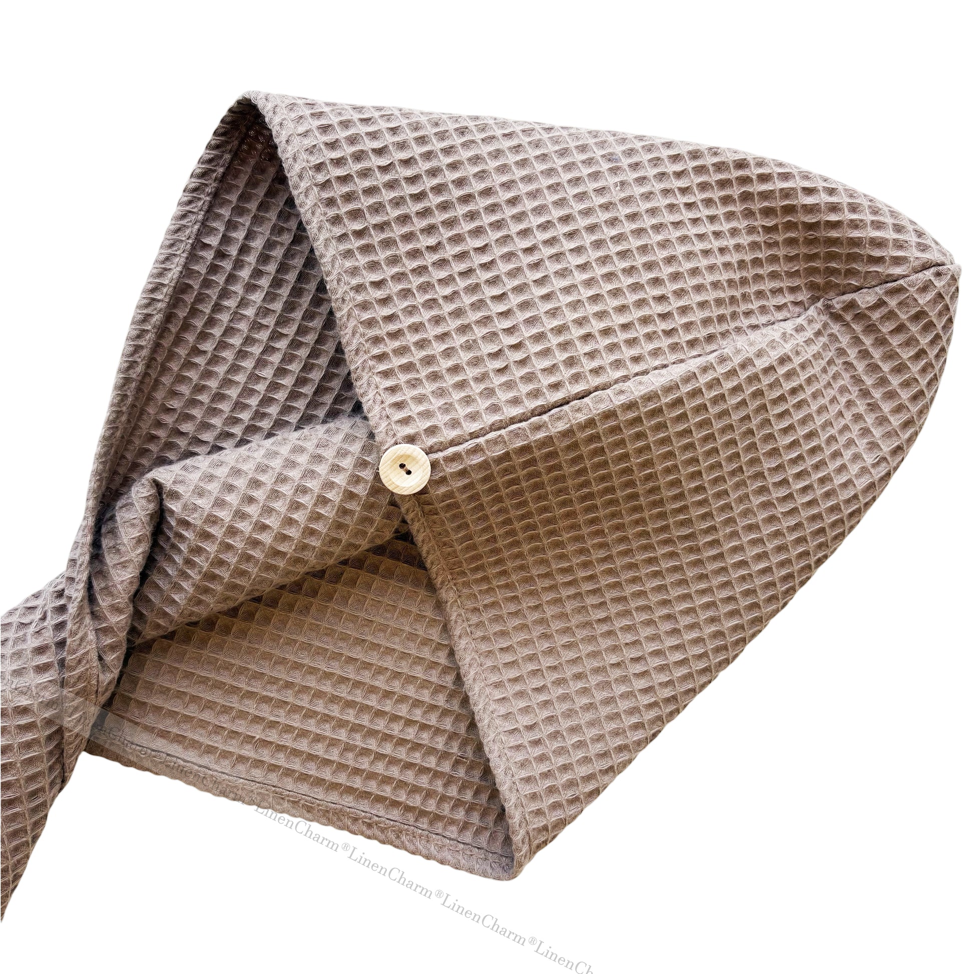 Beige textured fabric with a button on a white background